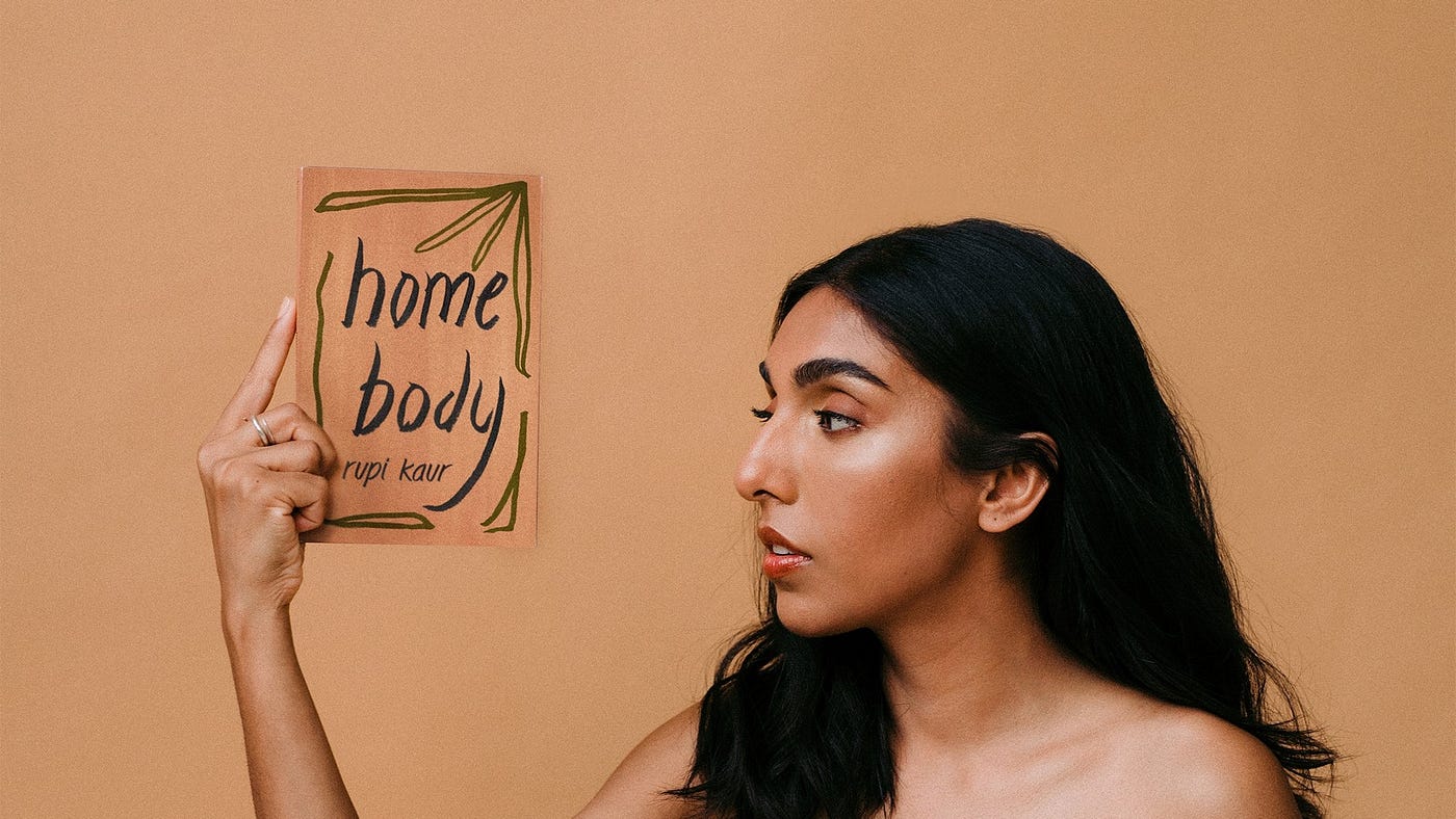 Poet Rupi Kaur holding her newest poetry book, Home Body