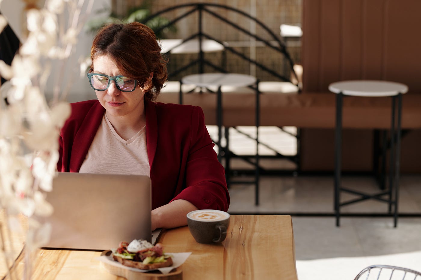 woman sitting at wood table using laptop
