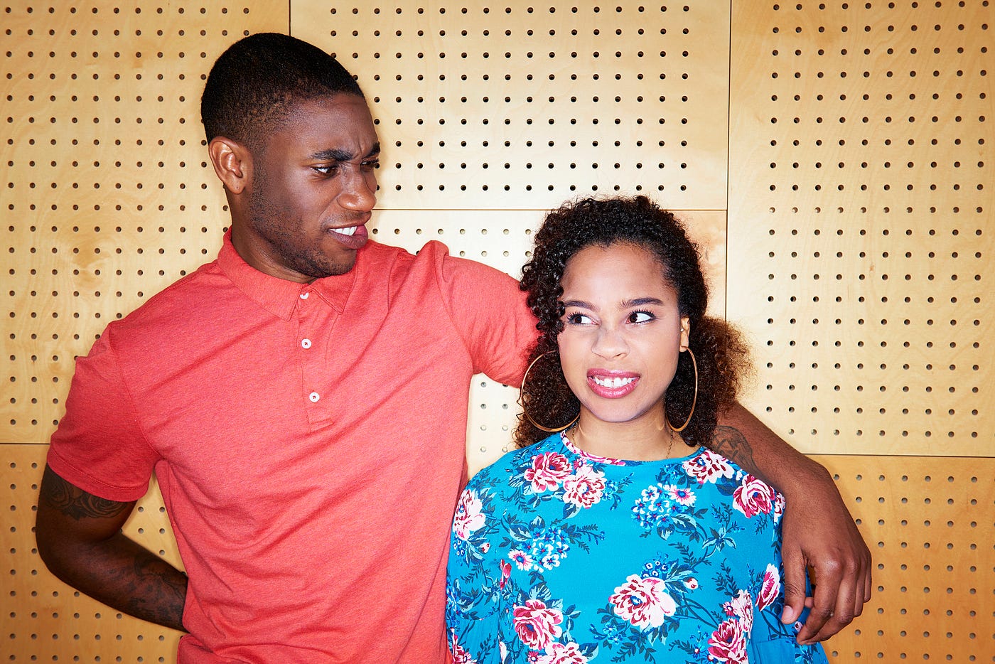 A photo of a black couple making faces at each other.