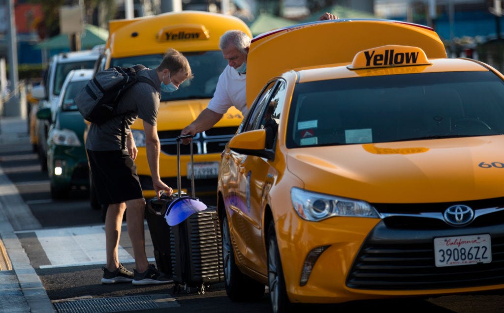 A cab driver helping a passenger load his luggage at LAX.