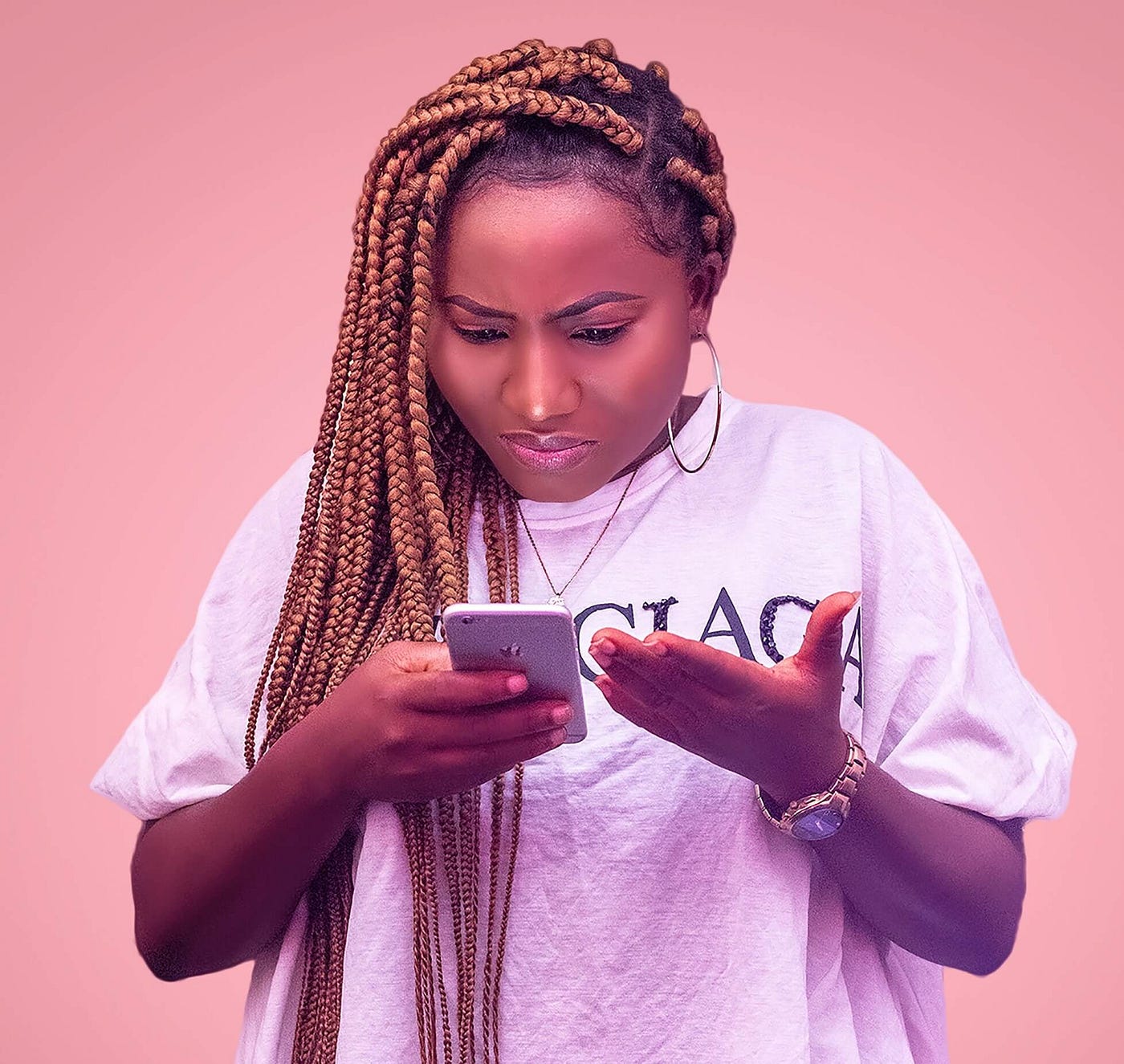 Black Woman with long braids looking at phone with a frustrated expression.
