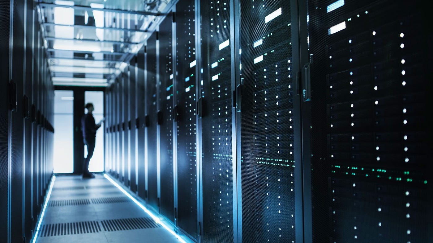 A dim room with server boxes. (https://www.streamdatacenters.com/the-top-4-advantages-of-a-private-data-center/)