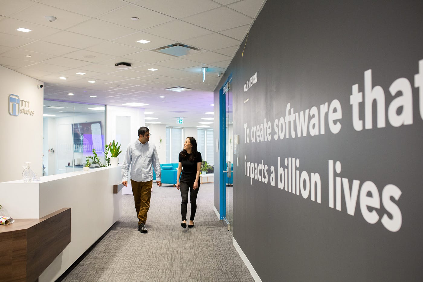 Two TTT employees laughing and walking down the hall together at the TTT office.