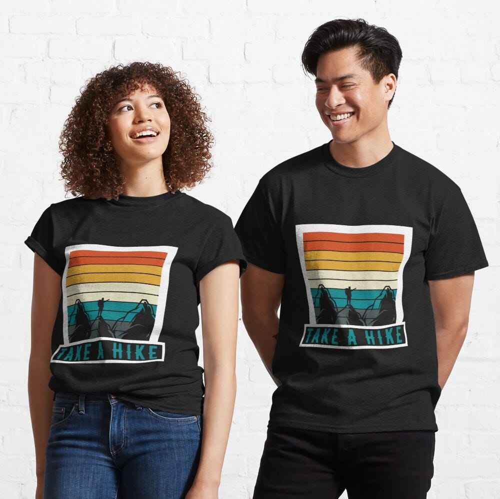 Man and Woman Wearing a black classic t-shirt with amazing illustration and text saying “take a hike”.