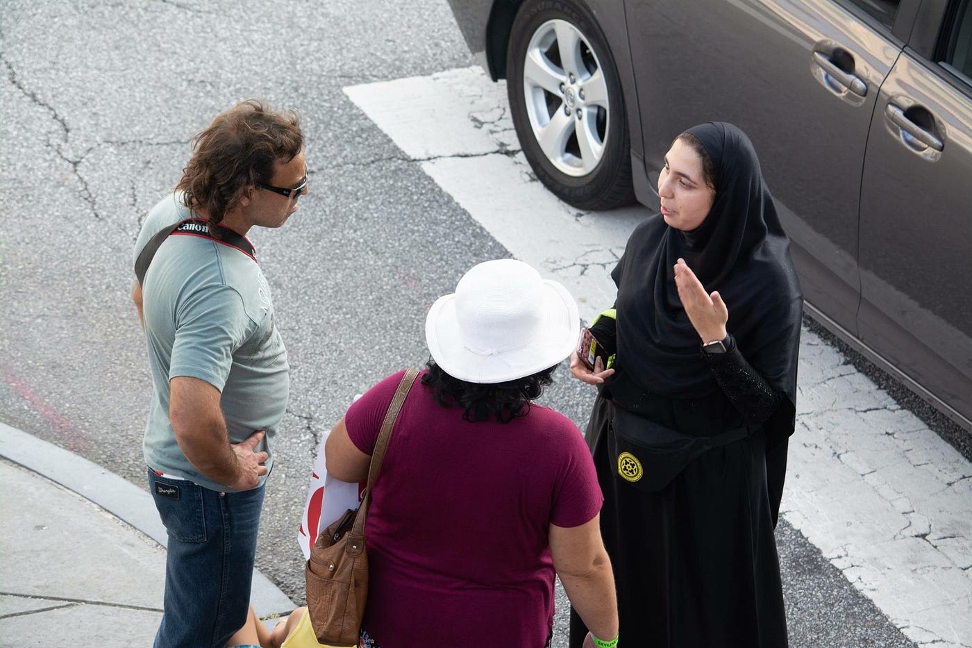 An image of Syeda speaking with two people on a sidewalk.