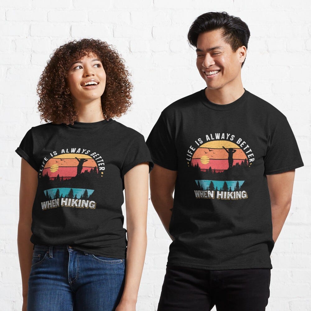 Man and Women wearing a black classic tshirt with amazing illustration and text saying “life is always better when hiking”.