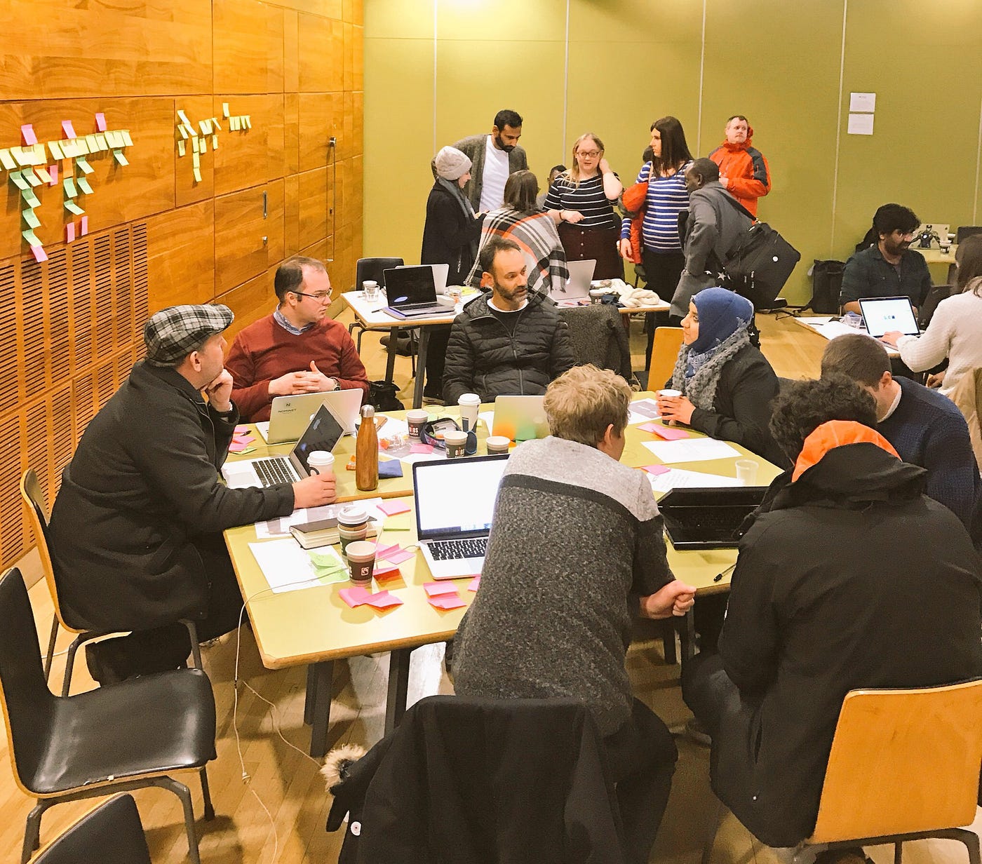 Room full of people — about 3 table groups of people chatting