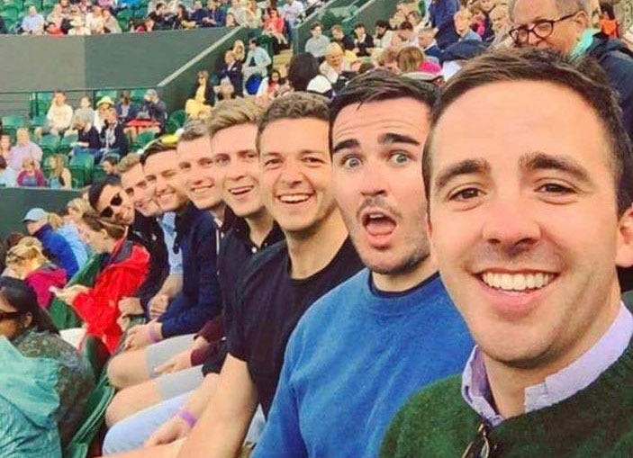 A line of young, white men, smiling at the camera.
