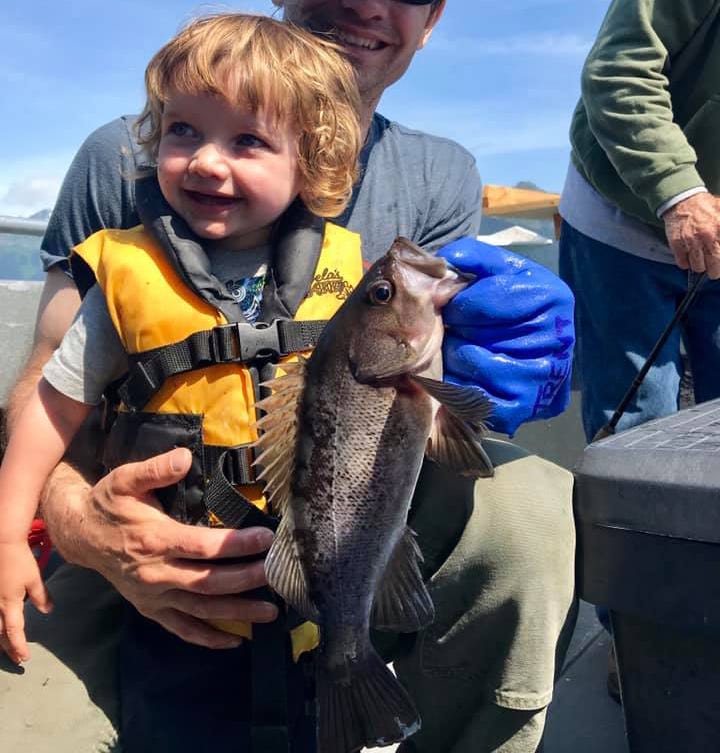 happy kid with a black rockfish