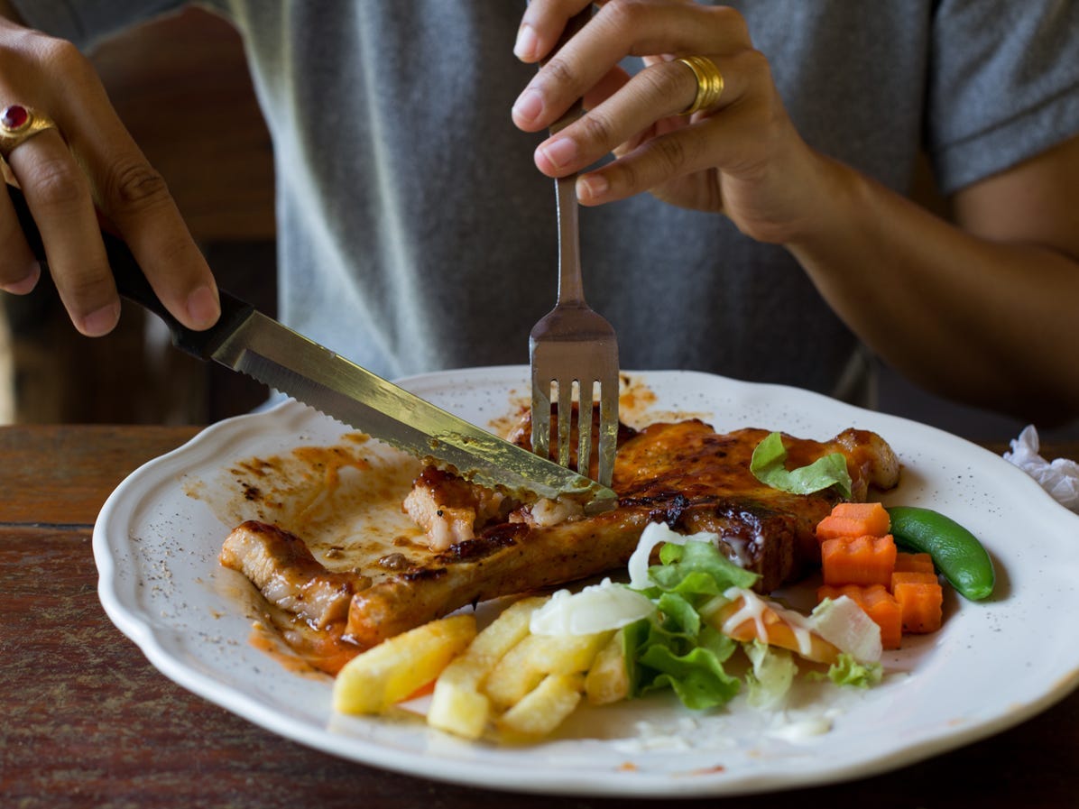 An individual cutting into food.