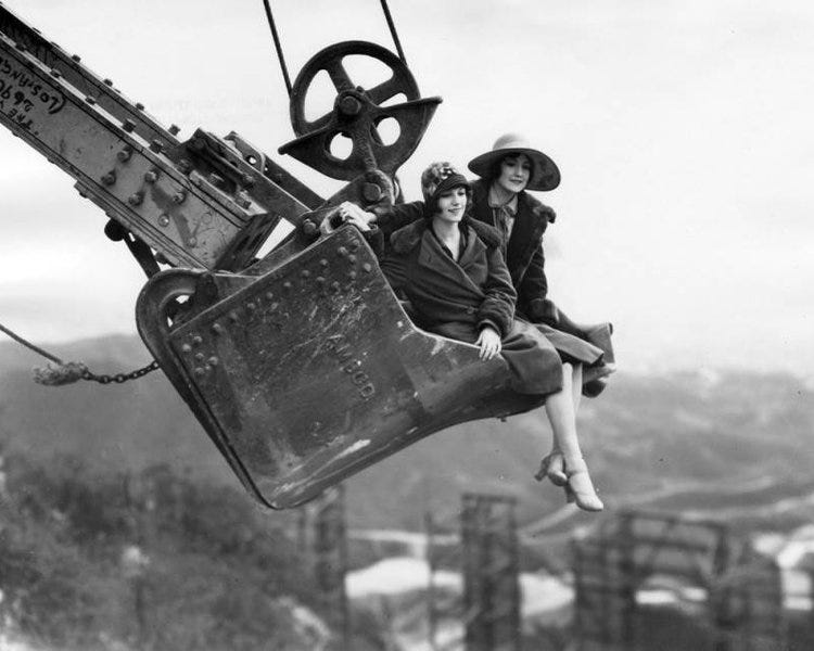 Publicity photo of two women sitting in a steam shovel above Hollywoodland. Photo via Los Angeles Public Library (1924)