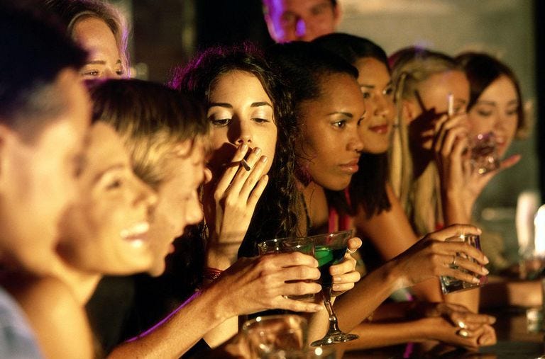 People in a bar enjoying legal drugs, alcohol and tobacco.