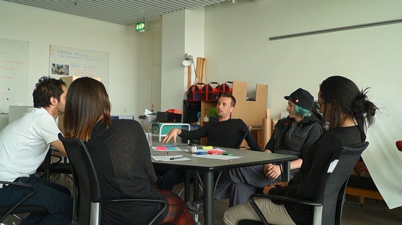 5 people sitting around a table.