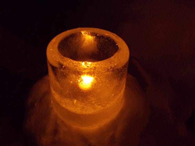 Candle burning on icy log