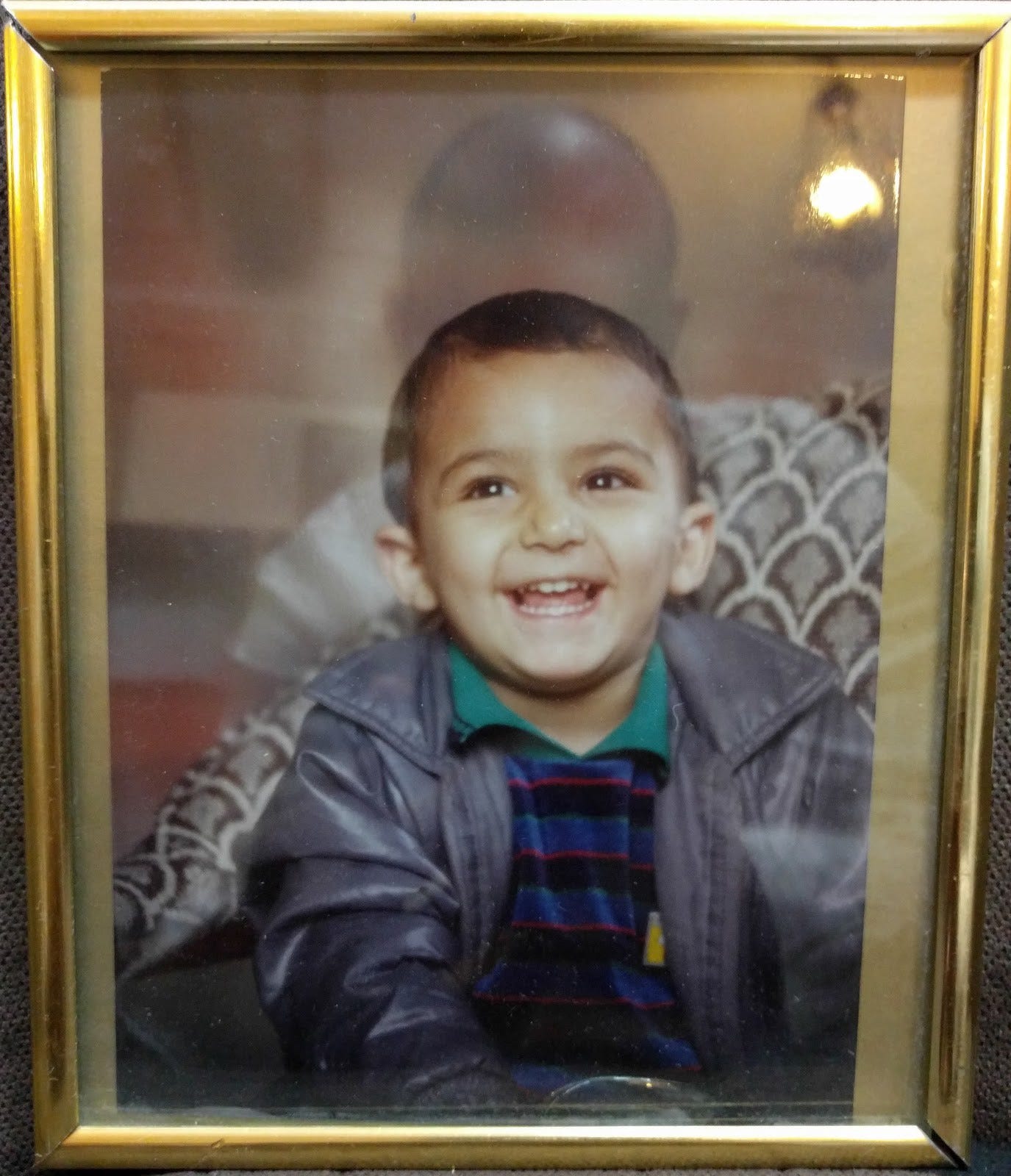 Toddler me, looking off camera and laughing. It’s a photo of a framed photo, so you can see the reflection of my adult head