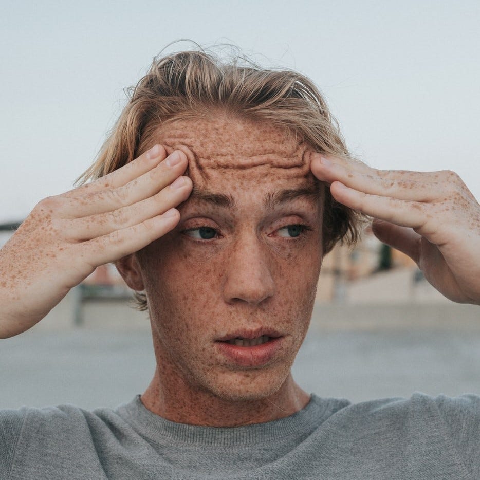 Confused man rubs eyebrows