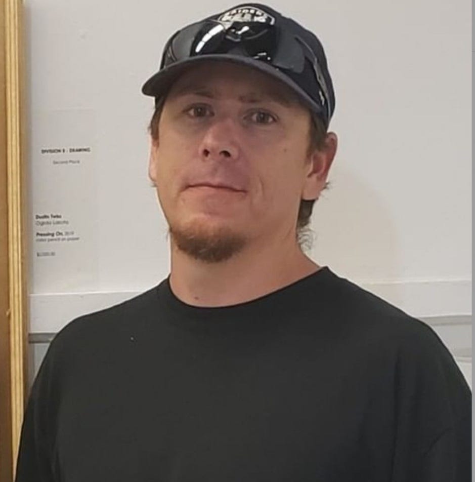 a man wearing a black baseball cap and black shirt