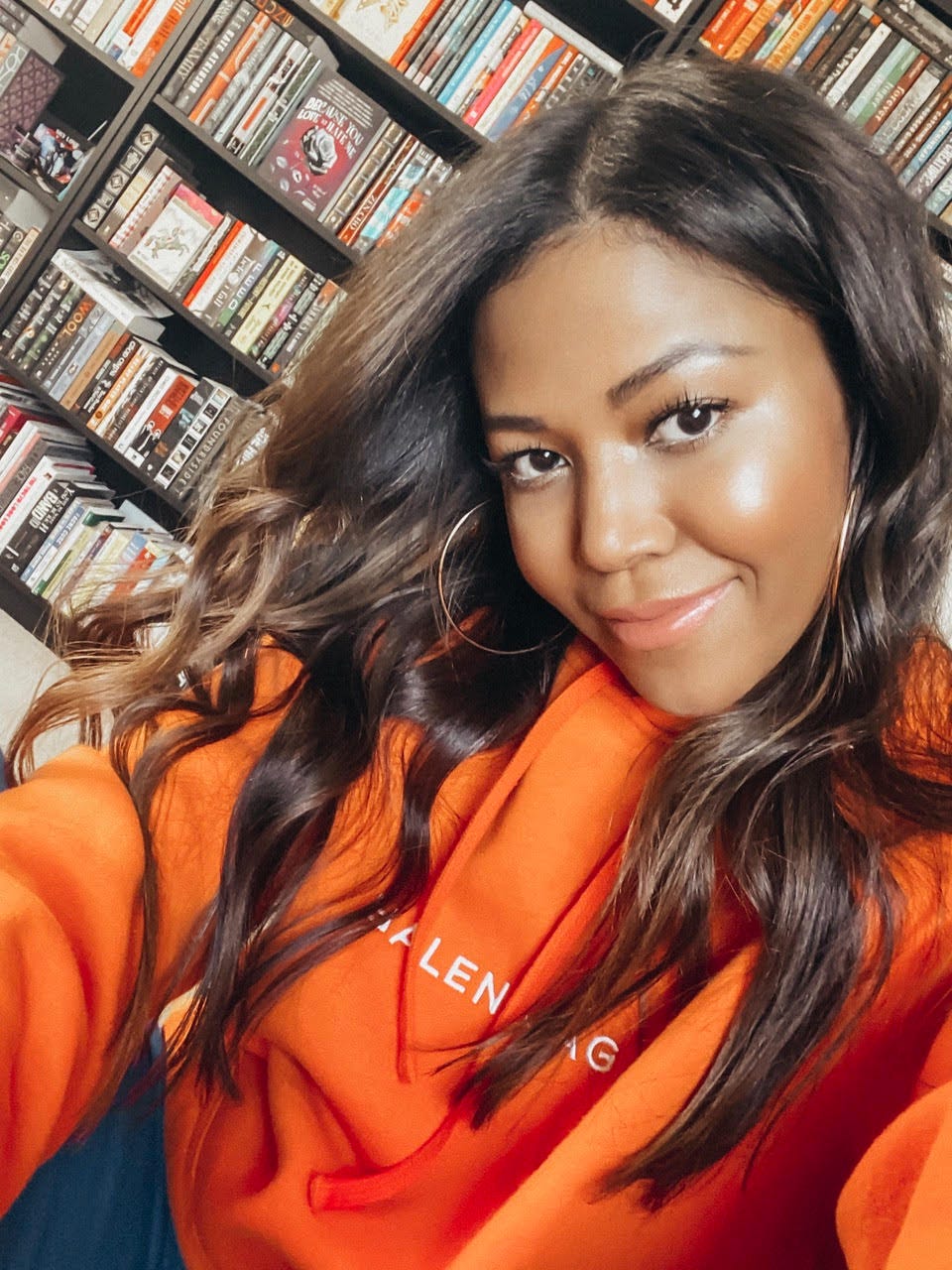 A selfie of Amerie with a bookshelf behind her.