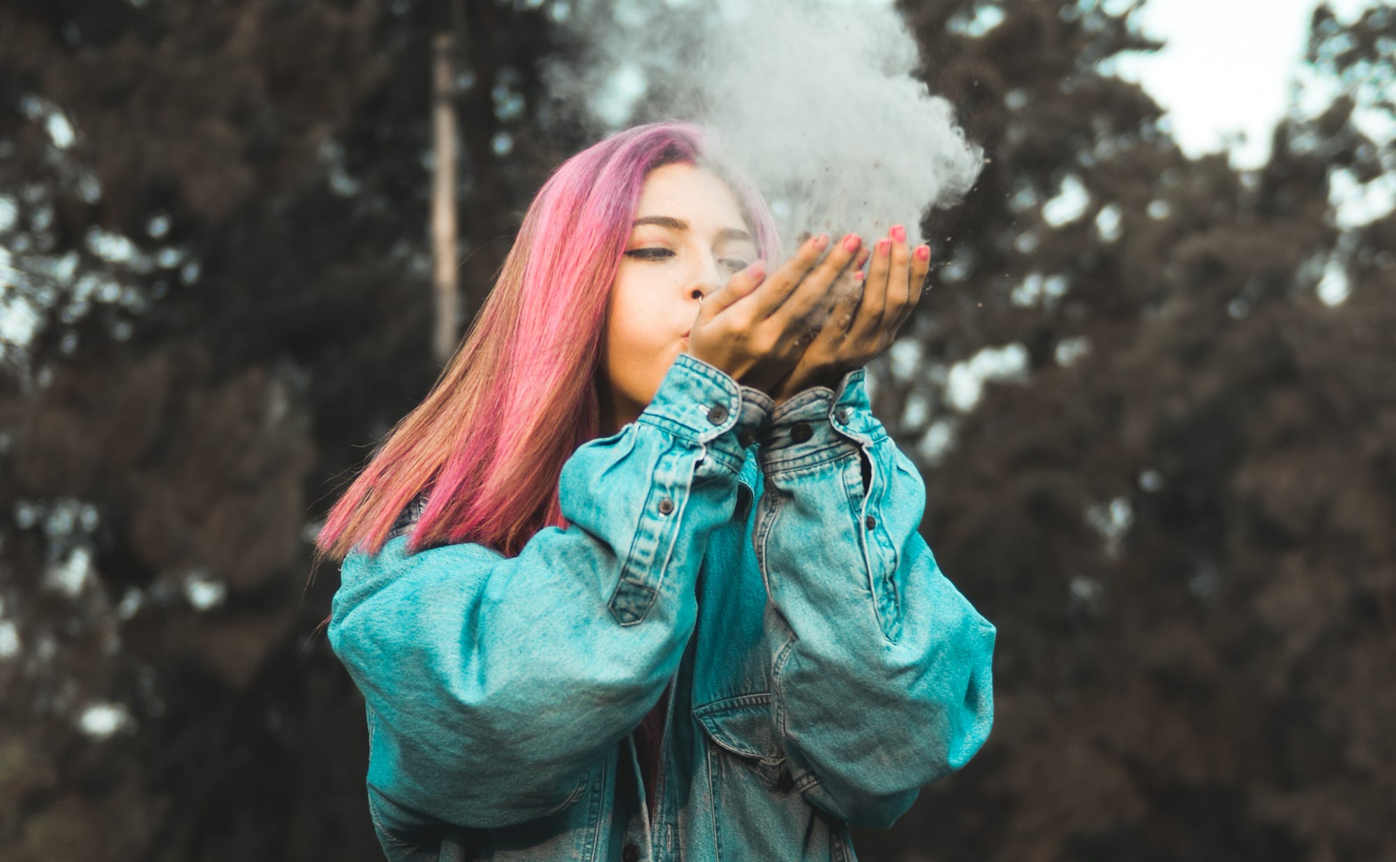 A woman blowing smoke out of her hands