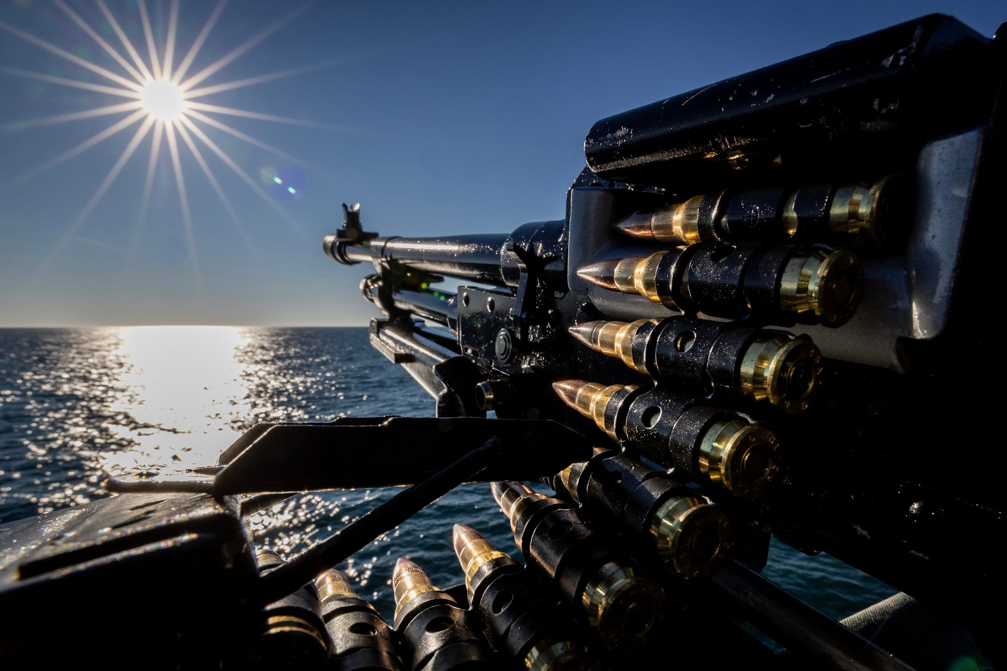 The sun glares onto the sea as HMS Lancaster sails.