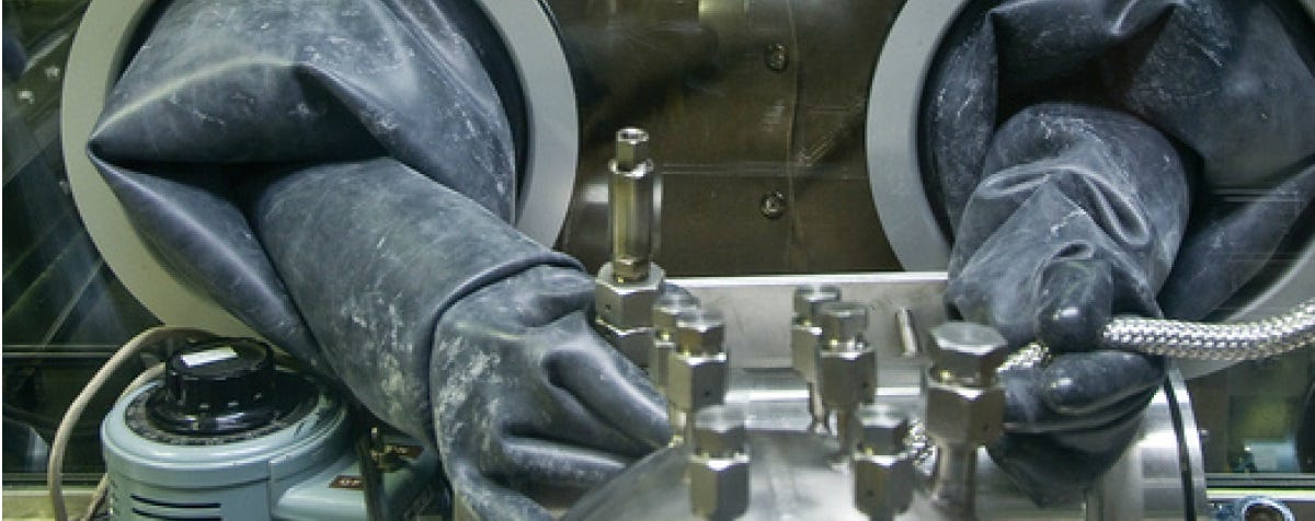 A close-up picture of a nuclear worker’s rubber gloves in a sealed facility
