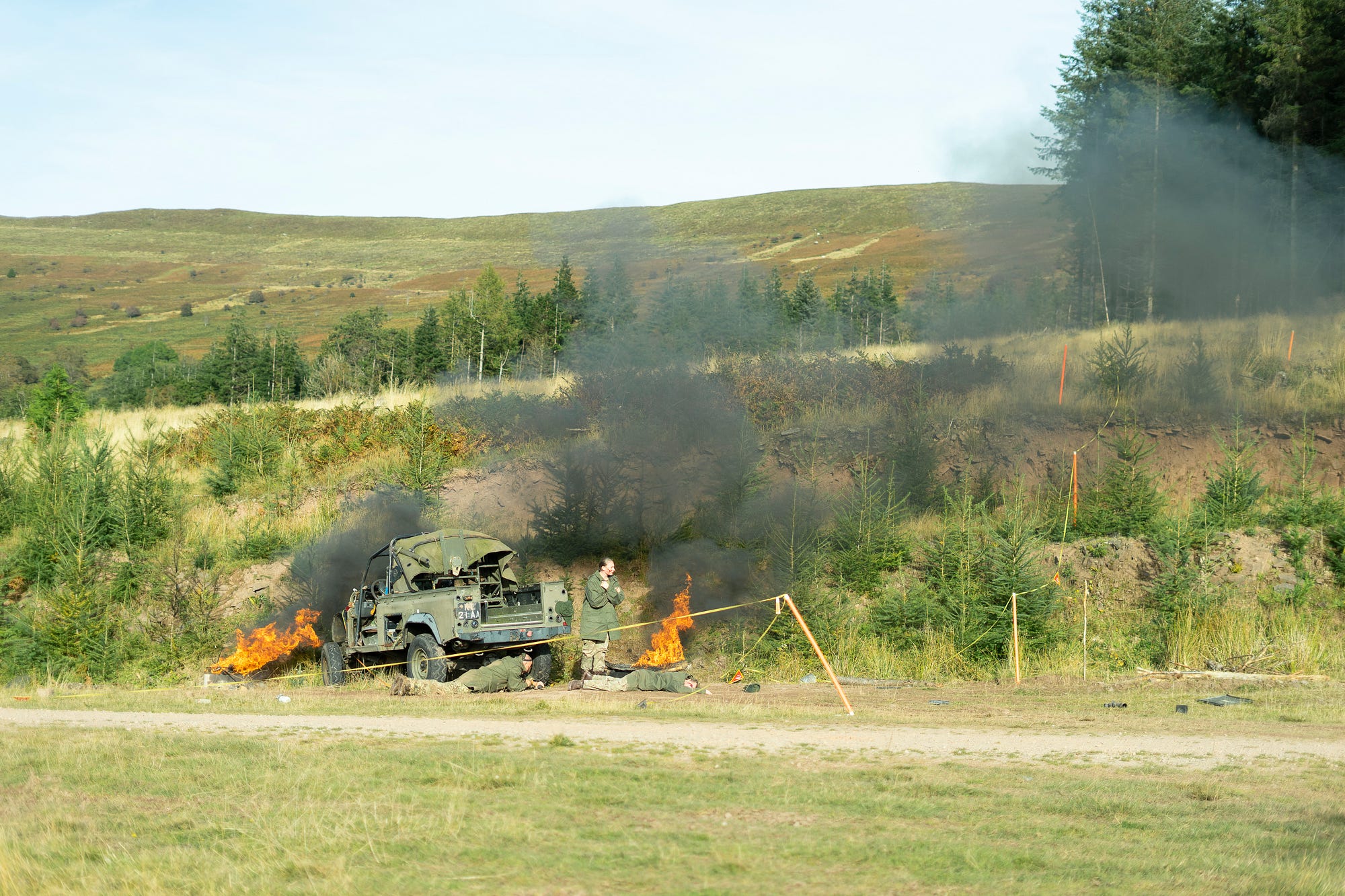 Directing Staff and Role Players from the UK Armed Forces during Cambrian Patrol 21, simulating a battlefield casualty scenario.