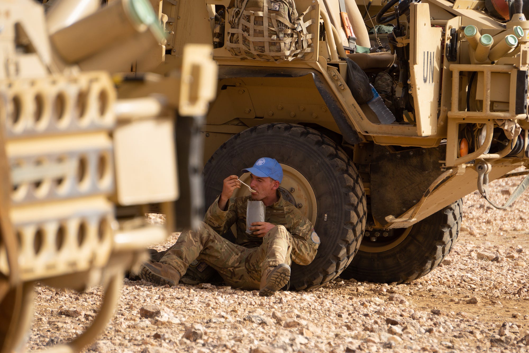A British peacekeeper stops to eat his ration.