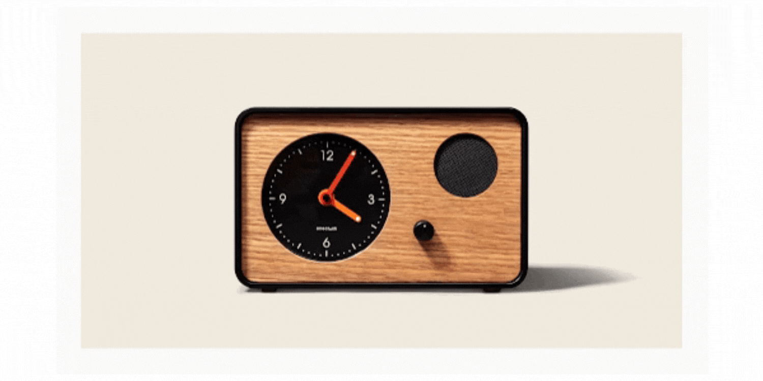 This is a gif image showcasing different angles of a wooden clock with a red plastic coverings. Showcasing the front, a zoomed in shot of knobs on it, a side angle shot, and the back of it.