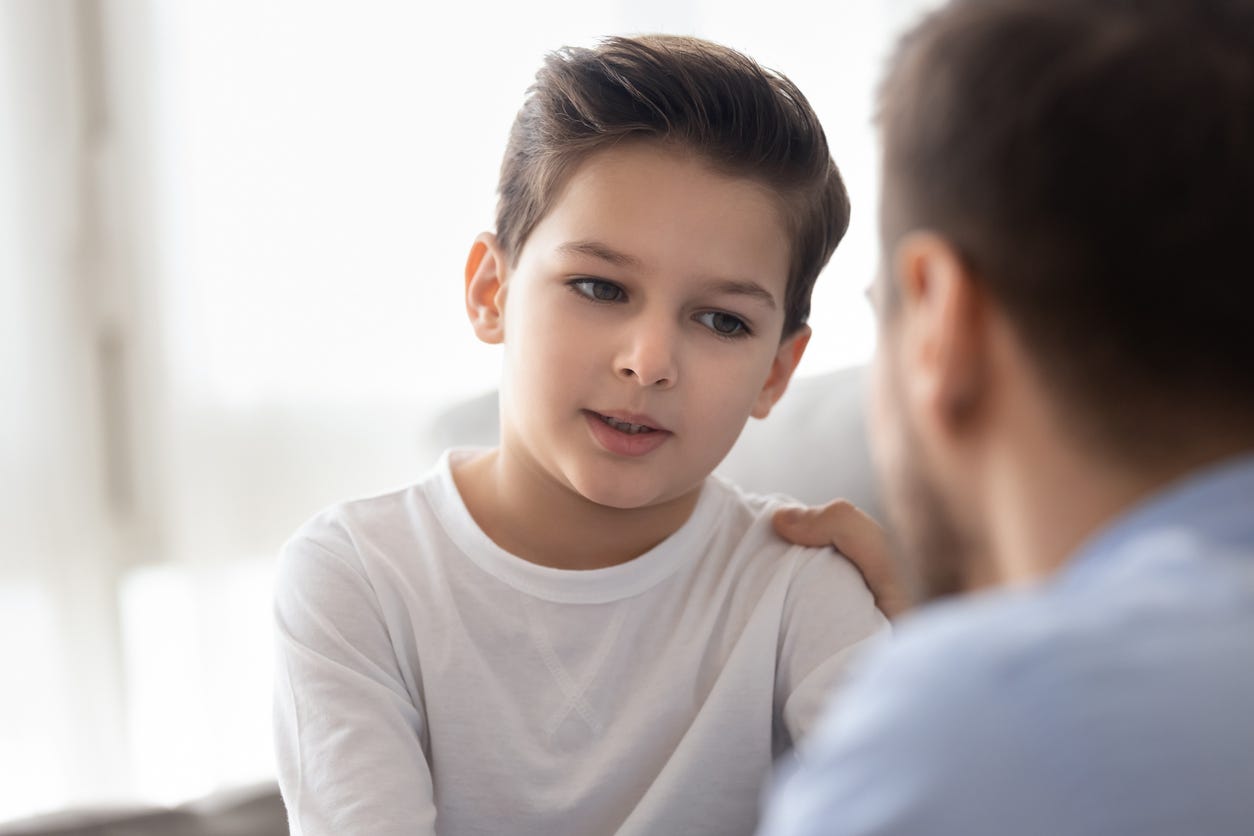 A young student talks to an adult.