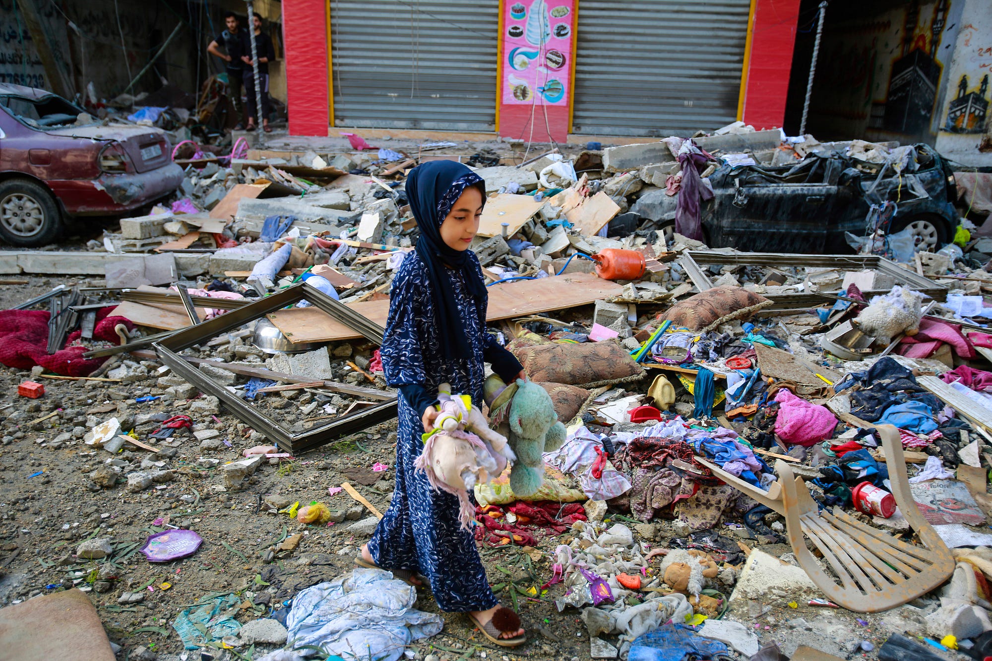 A Palestinian girl stands amongst destroyed building to collect her neighbours bears and toys in the aftermath of an Israeli airstrike on Gaza — 19 May 2021. (Photo by Ahmed Zakot / SOPA Images/Sipa USA)(Sipa via AP Images).