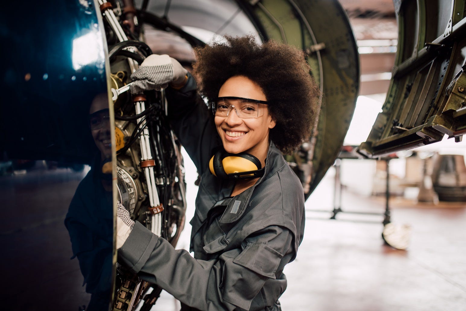 An aviation mechanic operating on an engine.