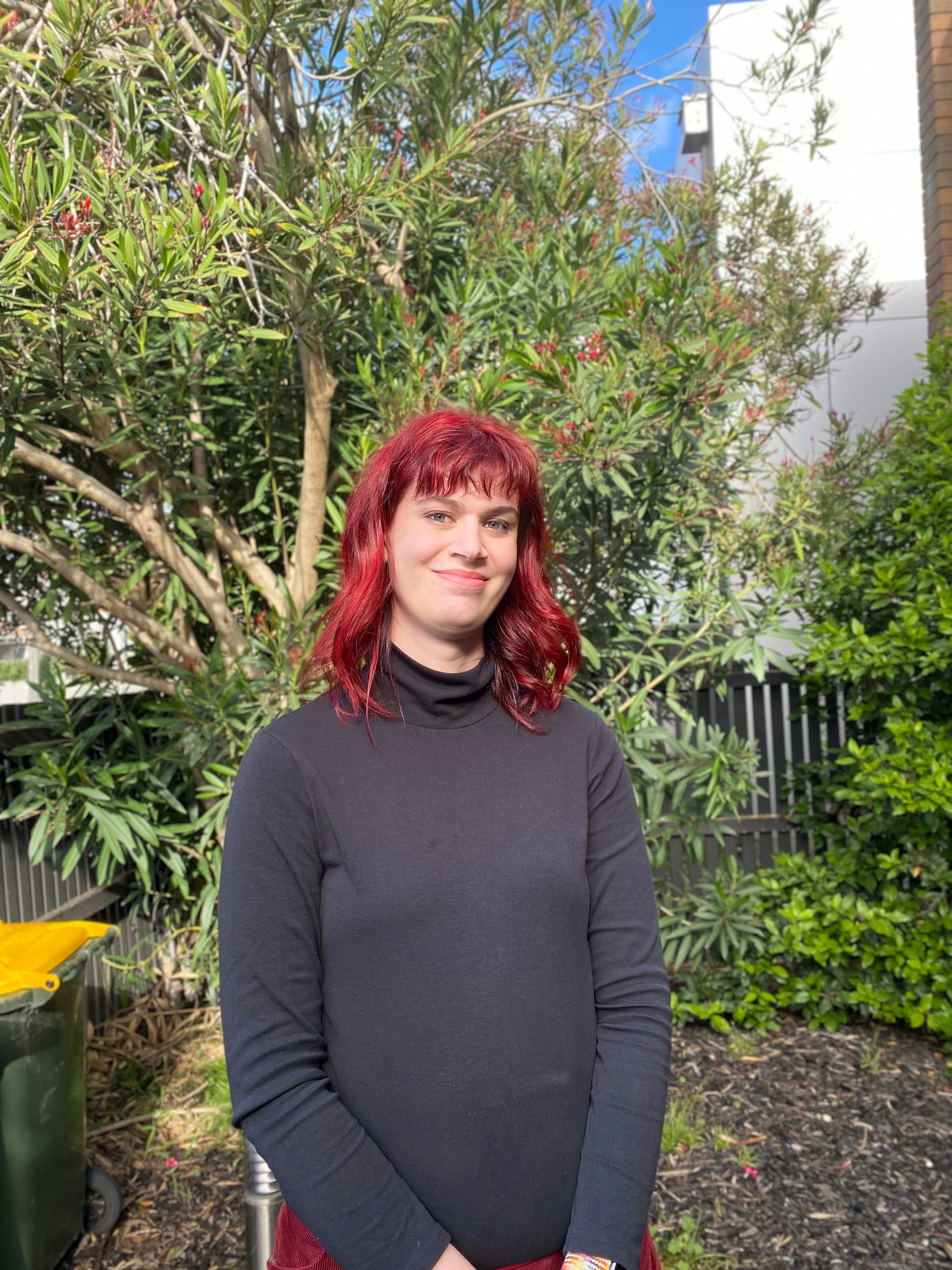 A Photo of the author with beautiful hair outside smiling,