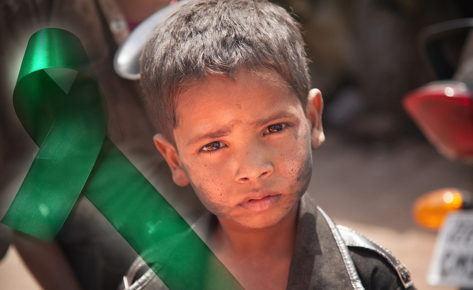 Street boy (India) alongside a green ribbon, symbol of mental health awareness. Photo 23755205 / © Ziprashantzi | Dreamstime.com