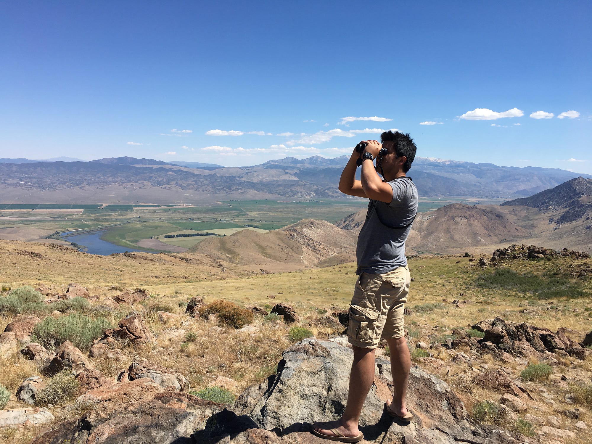 Jorge using binoculars to bird on a mountain