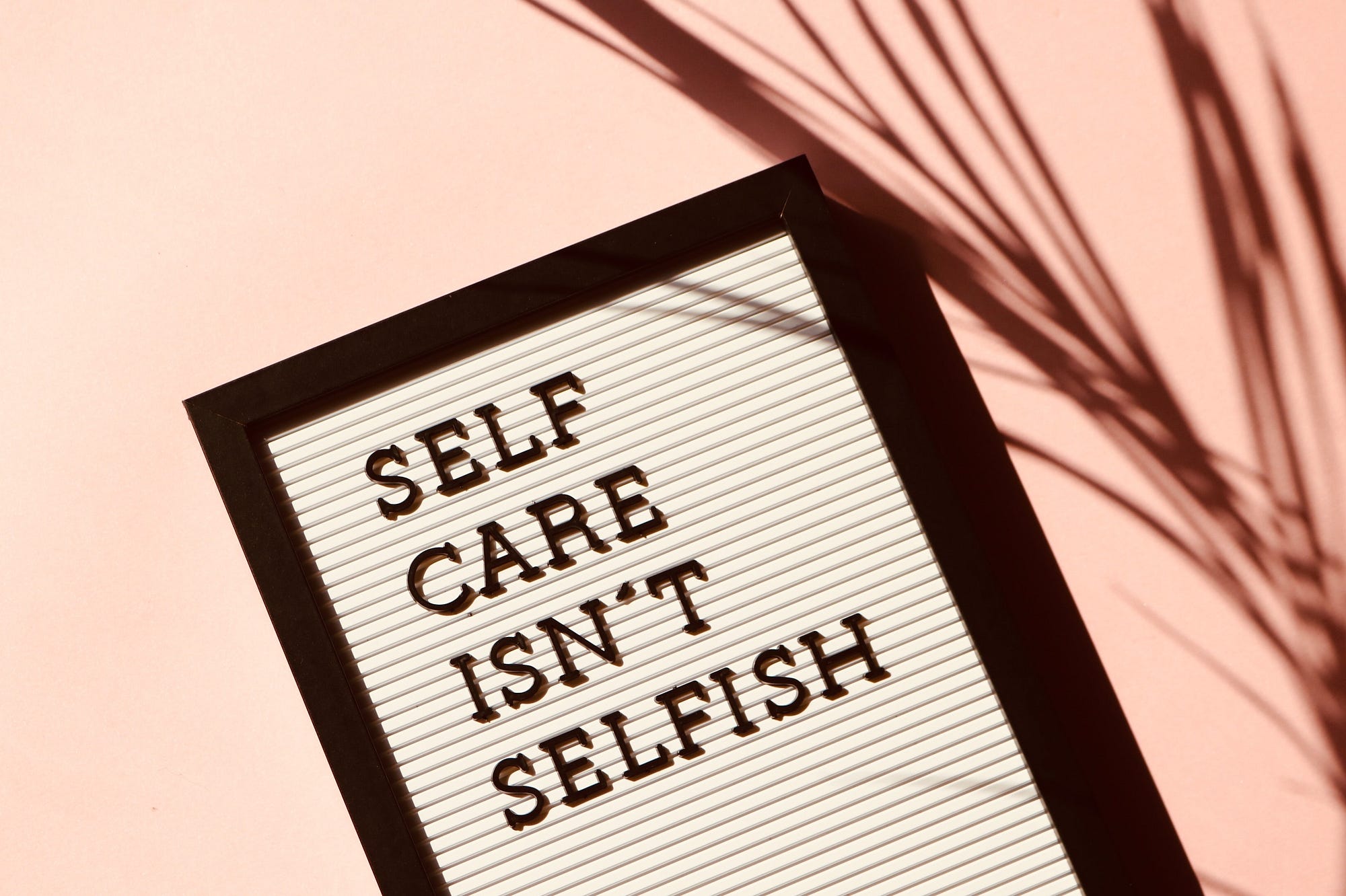 A sign that reads, “ self care isn’t selfish.”