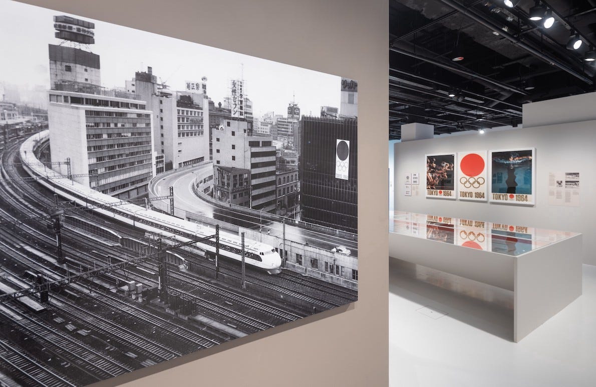 Exhibition space; photograph of Tokyo train with 1964 Olympic posters in the background