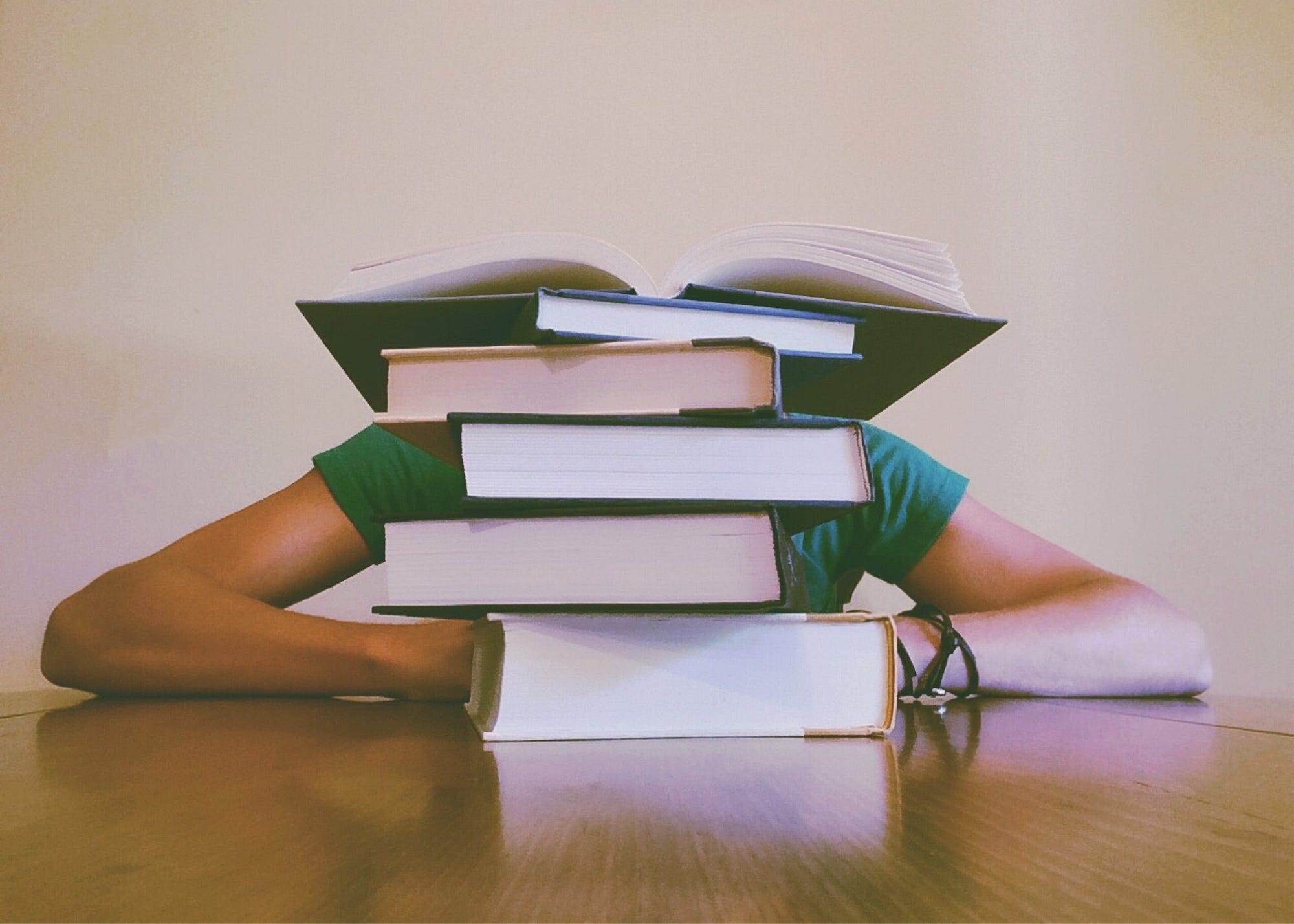 Person hidden behind stack of books