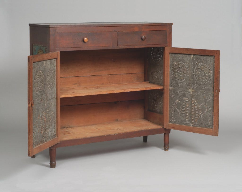Wooden pie safe with punched tin doors opened to reveal inner shelves.