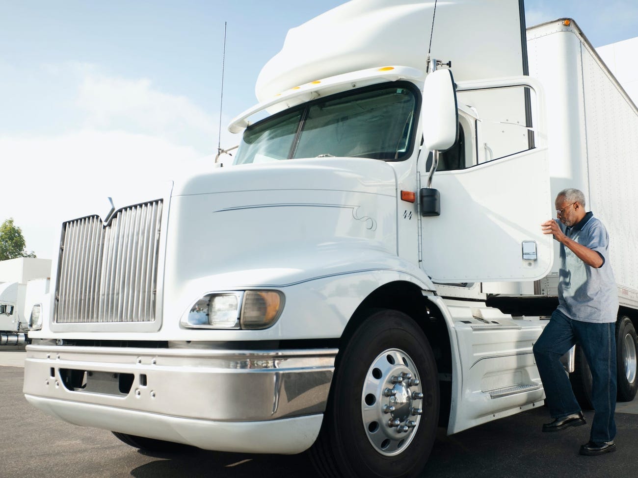 A man getting into a white truck.