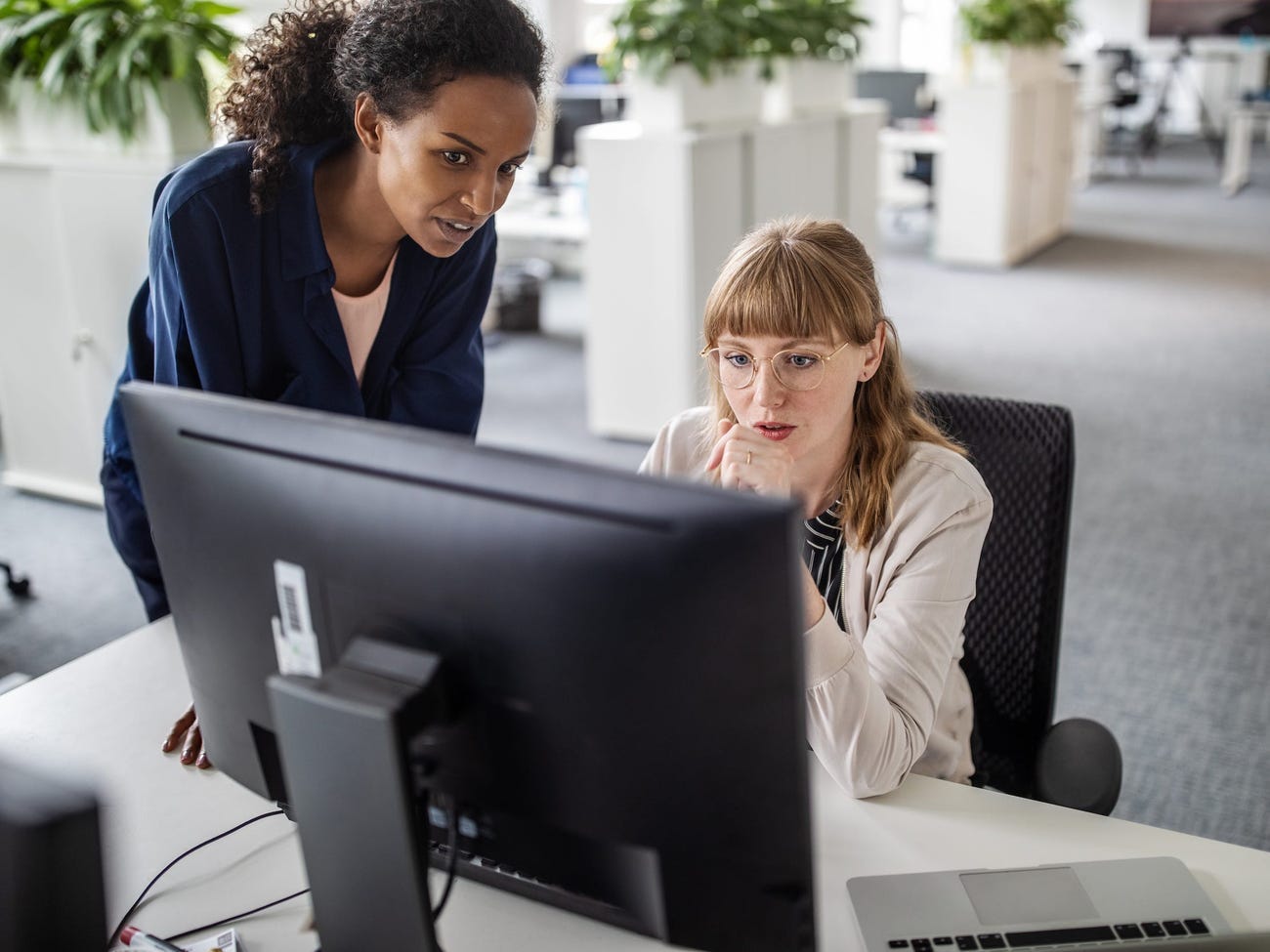 Two women looking at a desktop.