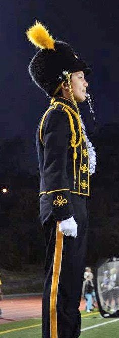 marching band conductor standing on a podium in uniform