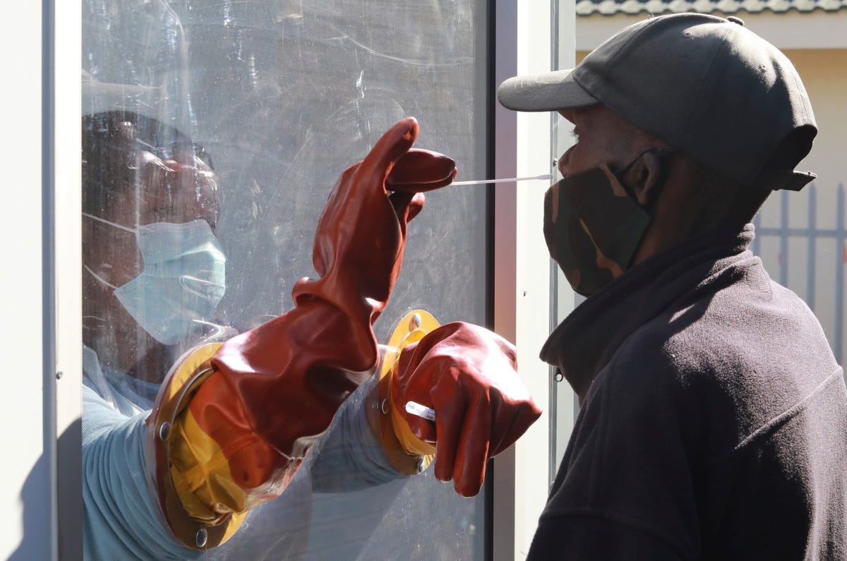 The health worker Vuyiseka Mathambo takes a nasal swab from a patient to test for COVID-19 in Cape Town, South Africa, in July 2020.