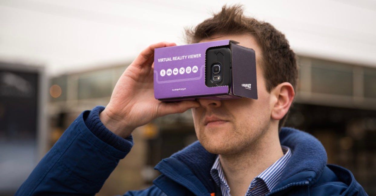 man holding cardboard Augmented Reality googles over eyes