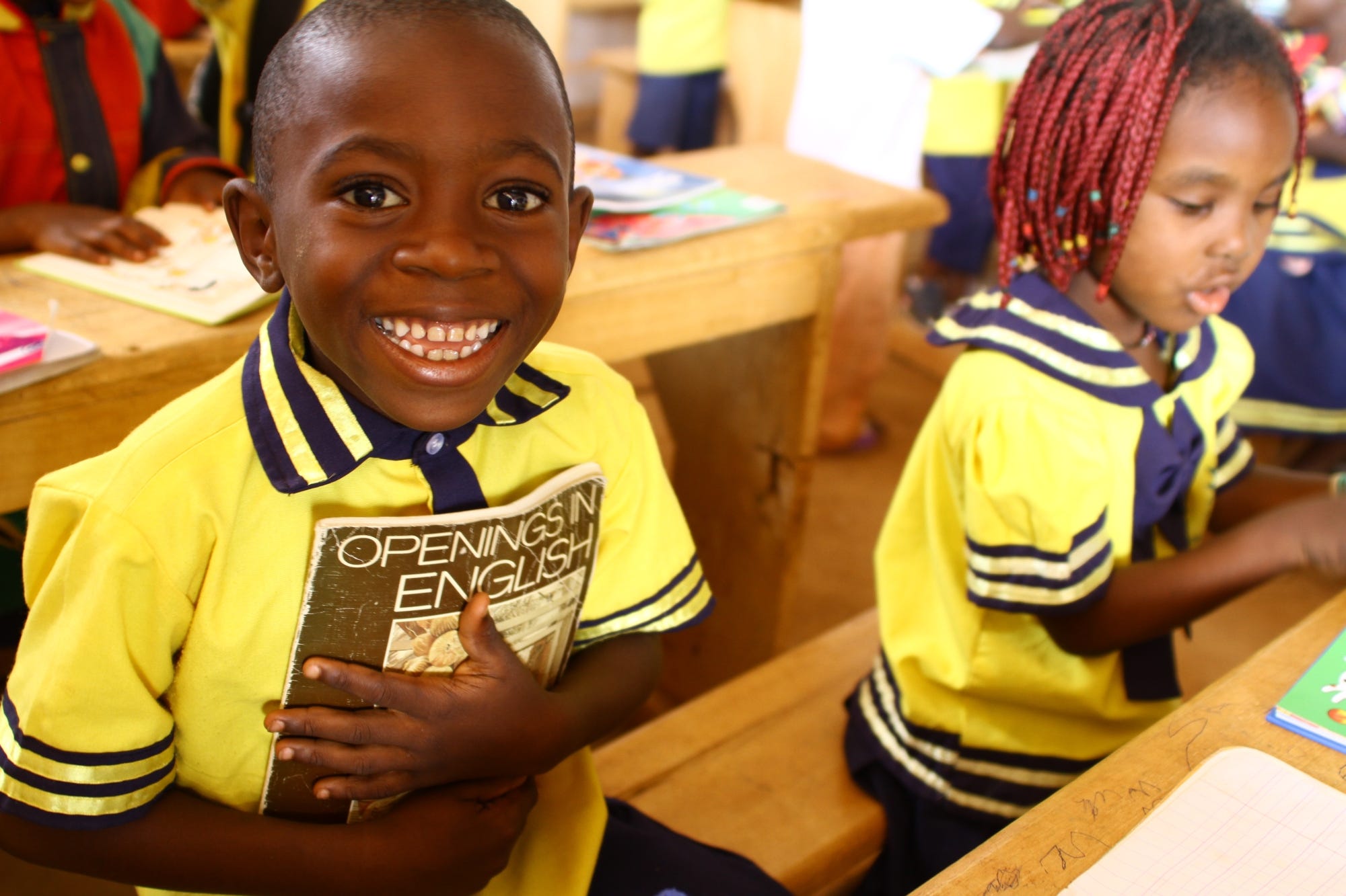 A boy in class holding an English textbook- Cameroon