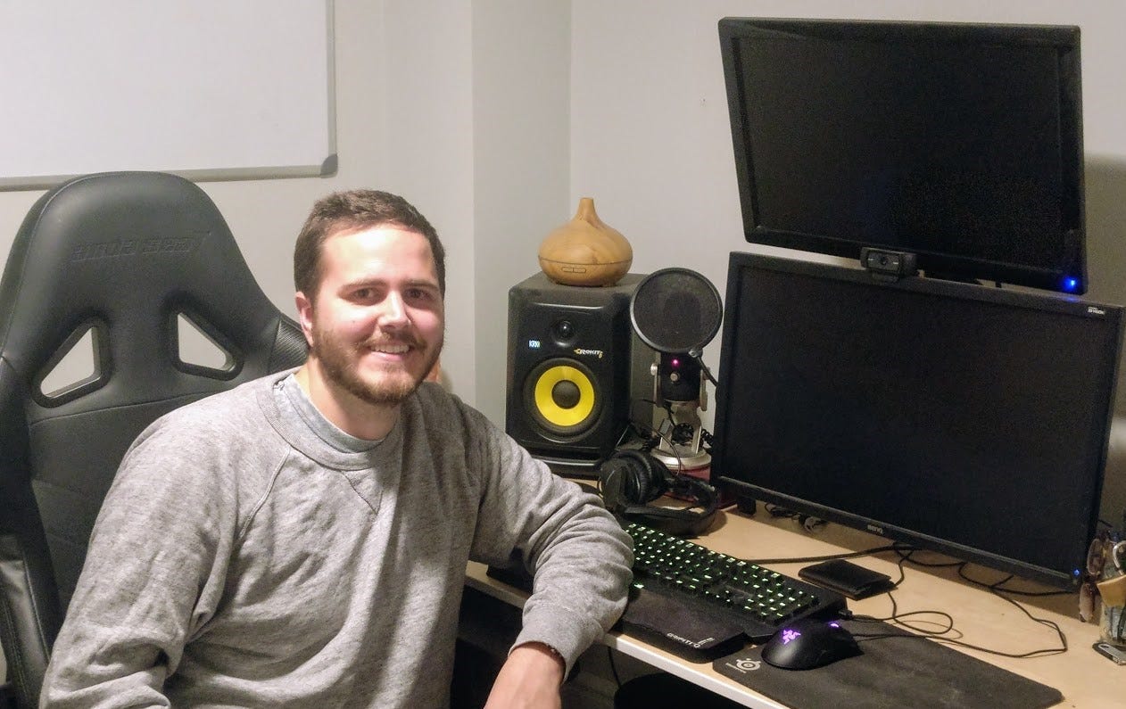 Me awkwardly sitting at my well-used home office
