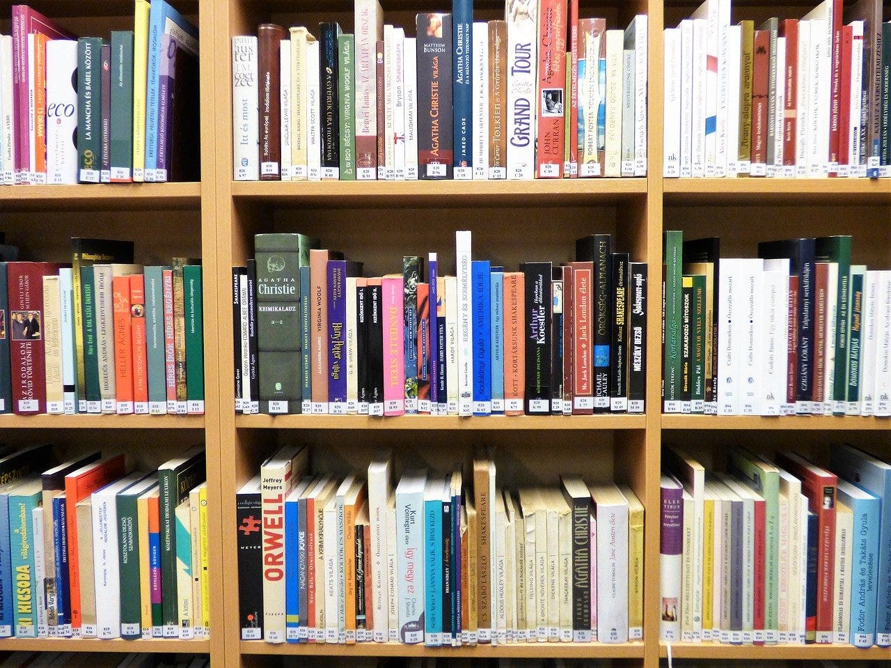 a bookshelf filled to the brim with books of all different colors, sizes, and genres