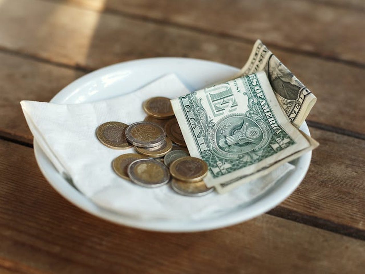 Money on a plate that was left as a tip.