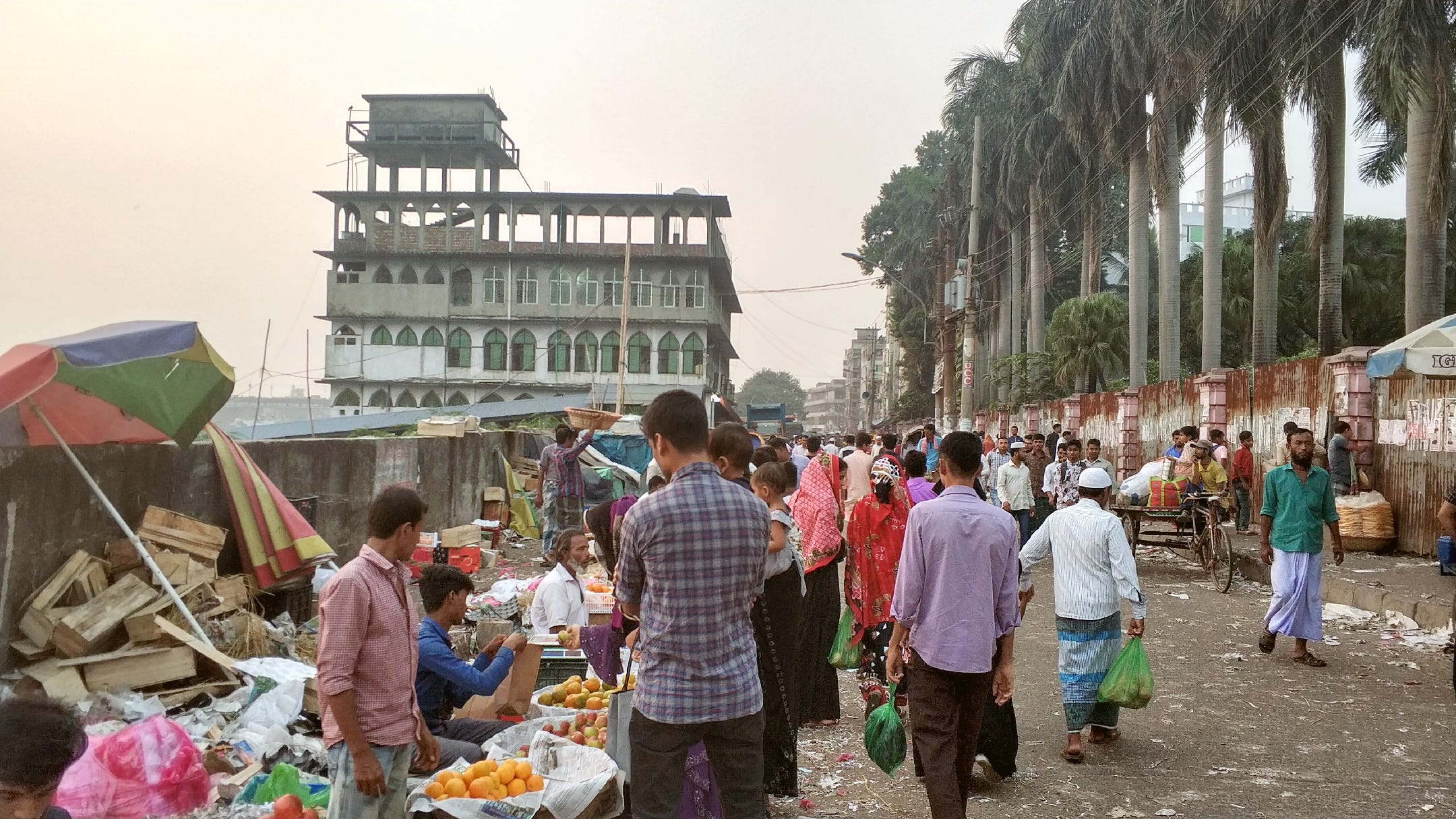 Fruit sellers tending to customers along the trash filled roads near the Buriganga River
