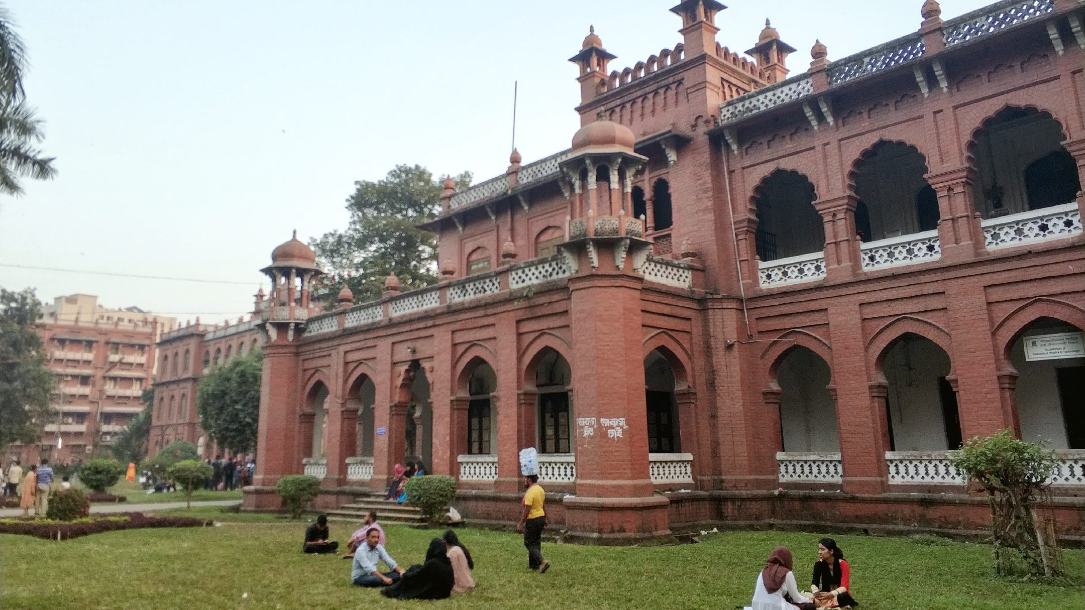Students chatting on the grass in front of Dhaka University’s Physics Department