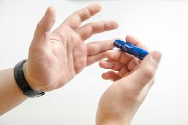 A man pricking his finger with lancet.